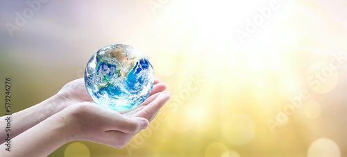 Leinwand Poster hands holding earth global over blurred abstract nature background