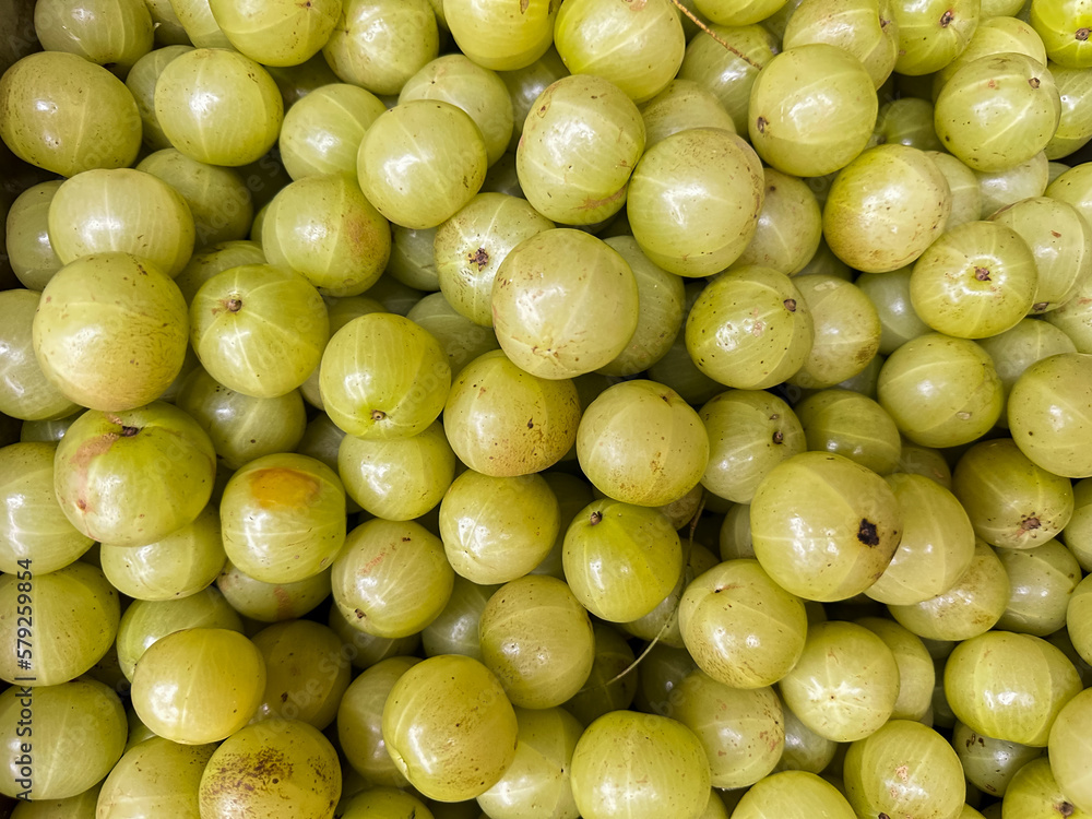 Indian gooseberry (Phyllanthus emblica) on local market. Gooseberry for sale in bazaar market. Fresh Amla fruit, Malacca tree, or amla fruit. Emblic fruits for sale in the fruit market