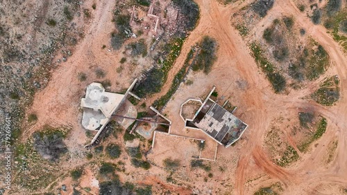 Aerial Virgin River gorge silver mine mill ruins climb 1. Southwestern desert near St George. Red stone and black volcanic mountain landscape. Geological landscape wind and water erosion. photo