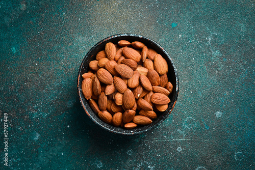 Almonds in a bowl. On a concrete background. Copy space.