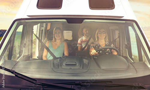 Front view through windshield of friends group traveling in camper van photo