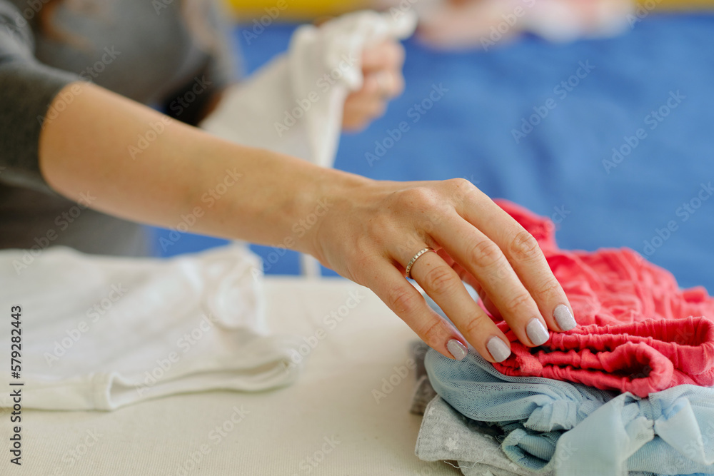 Fototapeta premium Closeup image of mother ironing clothes for her daughter