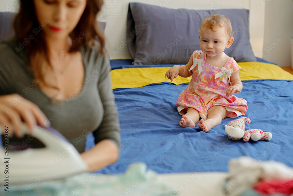 Little girl playing alone when her mother ironing clothes Little girl playing alone when her mother ironing clothes