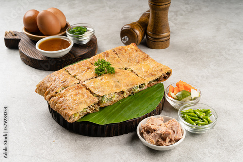 Martabak telur is indonesian street food  made with savory pan fried pastry stuffed with egg  spring onion  meat  sausage  spices and cheese.