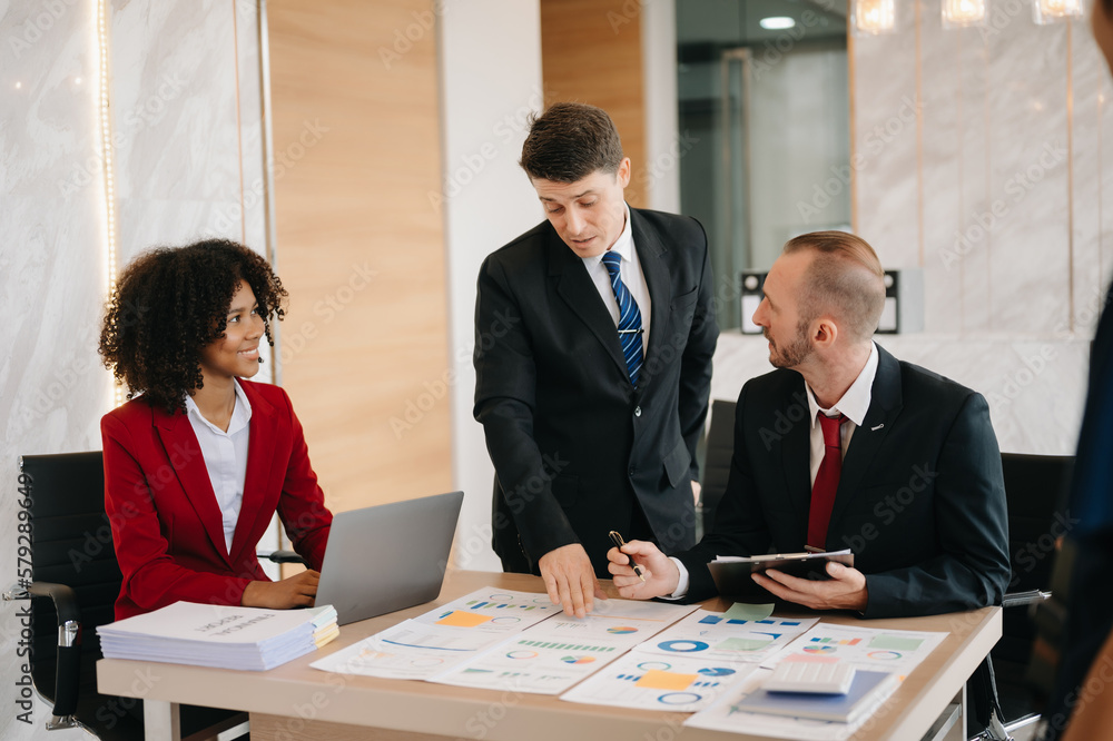 Happy businesspeople while collaborating on a new project in an office. Group of diverse businesspeople using a laptop and tablet in office.. Happy businesspeople while collaborating on a new project in an office. Group of diverse businesspeople using a laptop and tablet in office..