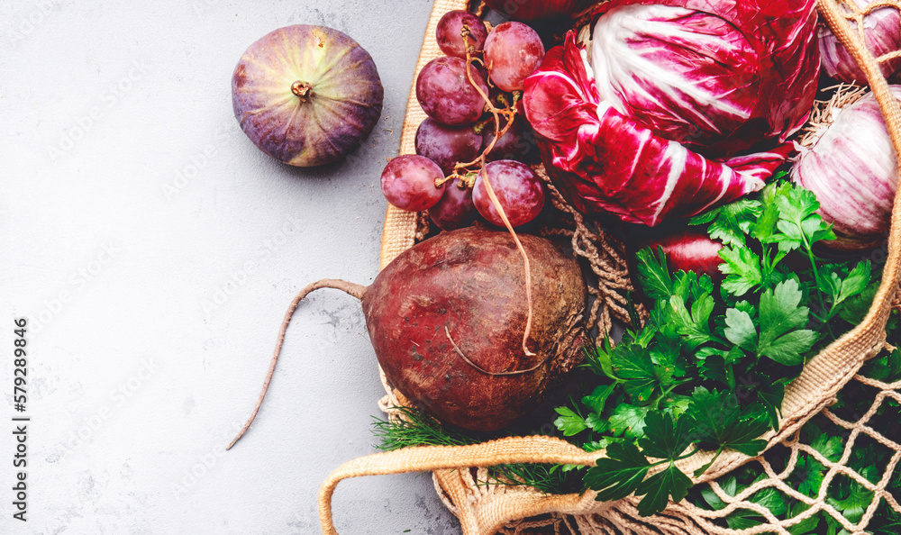 Food background with purple vegetables, roots and fruits in string
