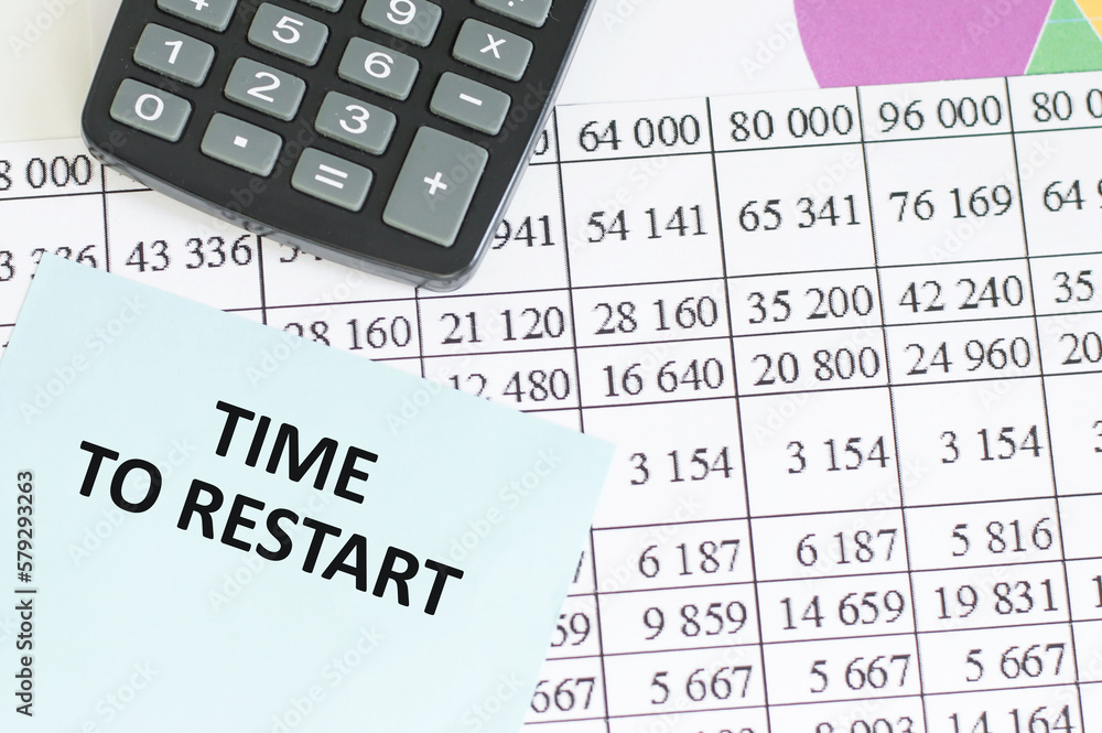 TIME TO RESTART text written on a notebook on background with chart and keyboard , business concept TIME TO RESTART text written on a notebook on background with chart and keyboard , business concept