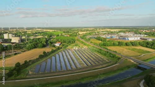 drone shot of a solar park on a street and a river in the countryside, drone flight back