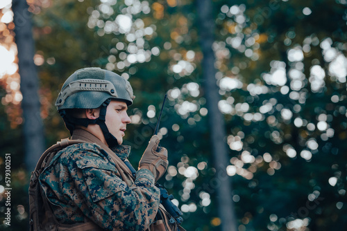 Fotografiet Modern Warfare Soldier Commander Officer Talking Portable Radio Station and Give