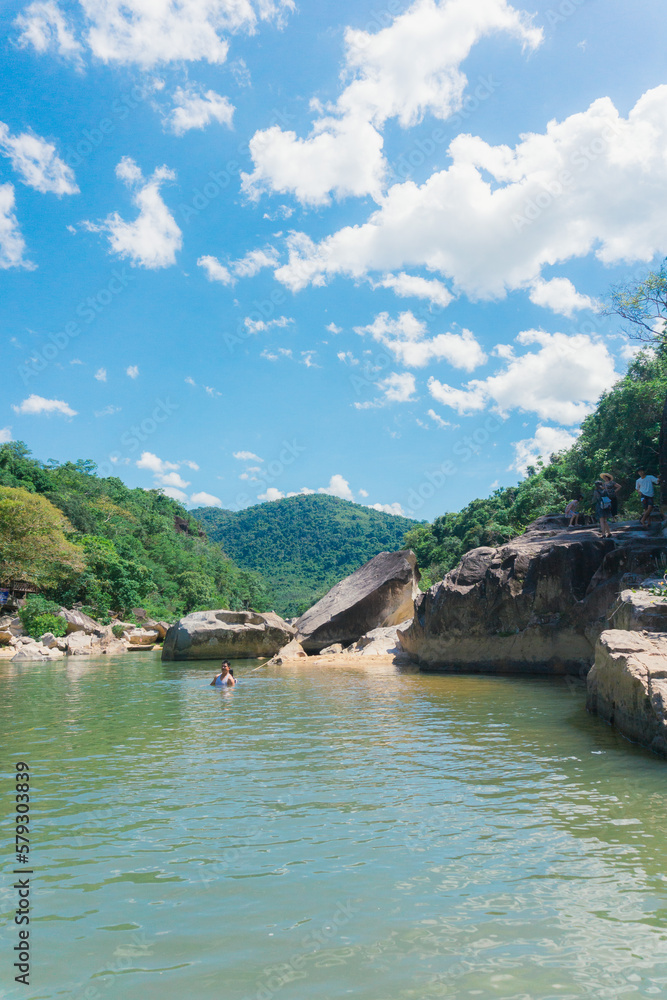 Tranquil natural scene with blue mountains, blue sky, and scattered rocks on the rippling river. Eco-tourism on a sunny day Tranquil natural scene with blue mountains, blue sky, and scattered rocks on the rippling river. Eco-tourism on a sunny day
