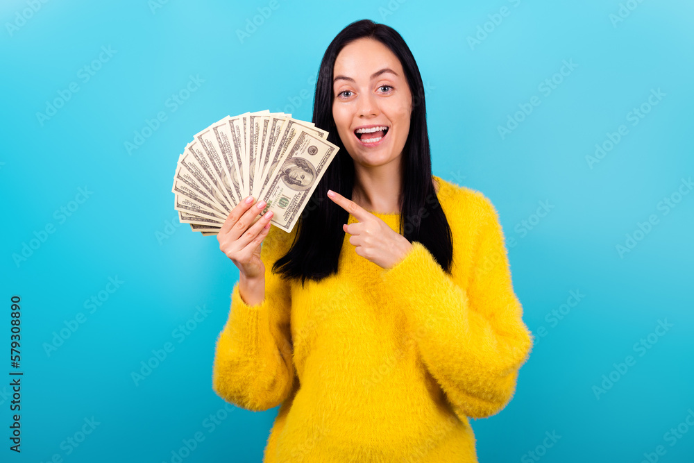 Photo of funny millennial brunette lady point money wear yellow sweatert isolated on blue color background
