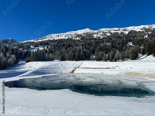 Beautiful winter atmosphere on storage lake Valos or reservoir lake Valos (Speichersee Valos) above the tourist resorts of Valbella and Lenzerheide in the Swiss Alps - Canton of Grisons, Switzerland