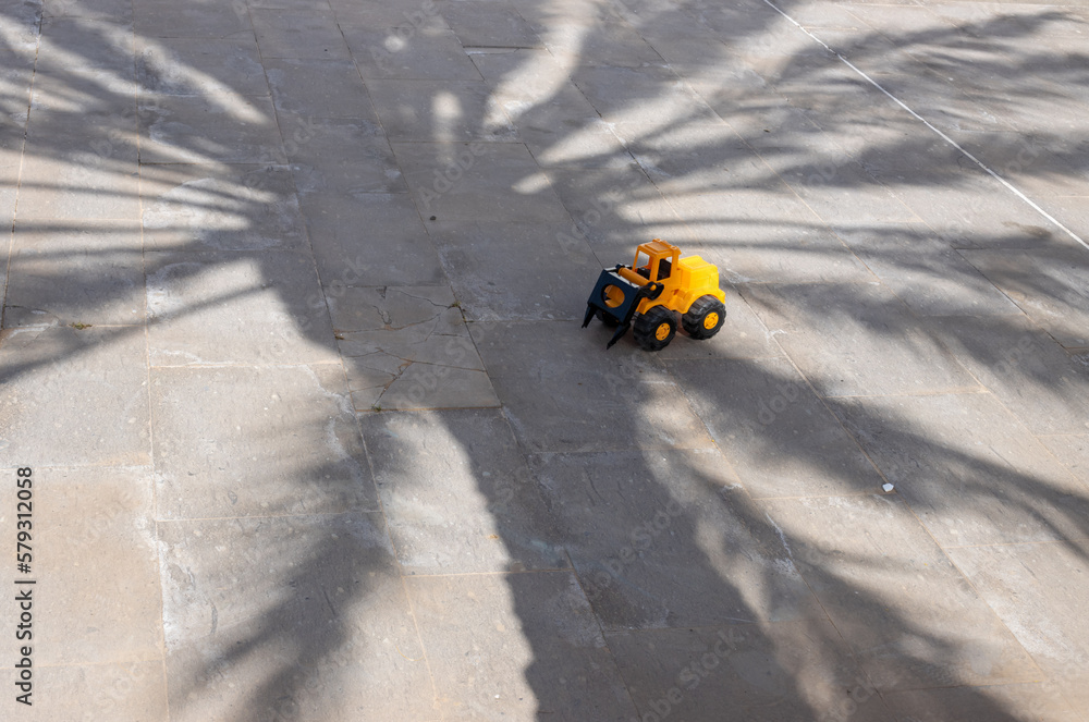 Forgotten toy in a shadow of a palm tree Forgotten toy in a shadow of a palm tree