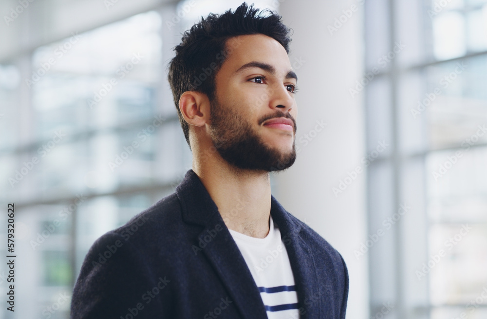 He cant afford to rest on his laurels. Cropped shot of a young businessman showing thumbs up while walking through a modern office. He cant afford to rest on his laurels. Cropped shot of a young businessman showing thumbs up while walking through a modern office.