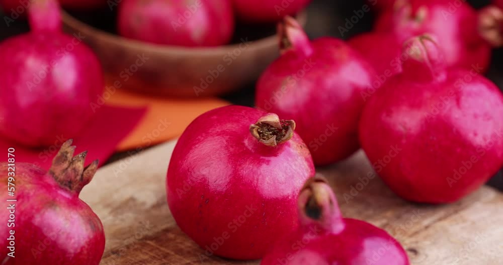 Ripe red pomegranate on the table with other pomegranates, ripe red pomegranate of the harvest Ripe red pomegranate on the table with other pomegranates, ripe red pomegranate of the harvest