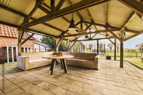Quadro em tela an outdoor living area with wood beams and stone flooring in the room is very la