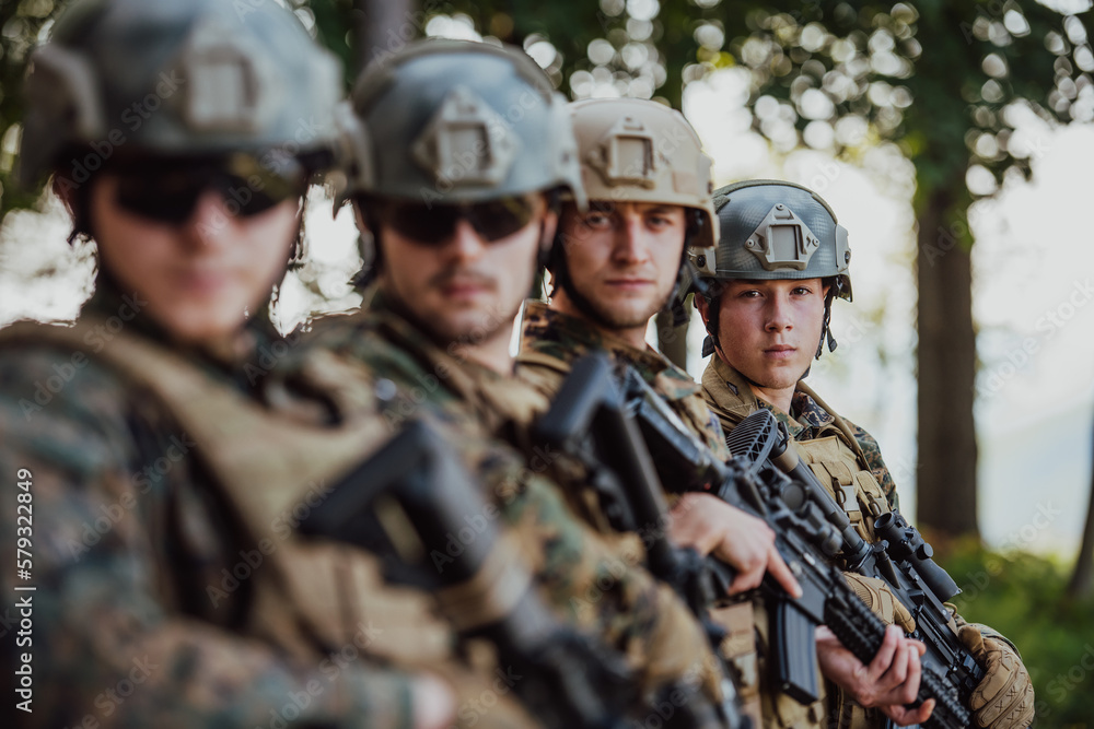 Soldier fighters standing together with guns. Group portrait of US army elite members, private military company servicemen, anti terrorist squad Soldier fighters standing together with guns. Group portrait of US army elite members, private military company servicemen, anti terrorist squad
