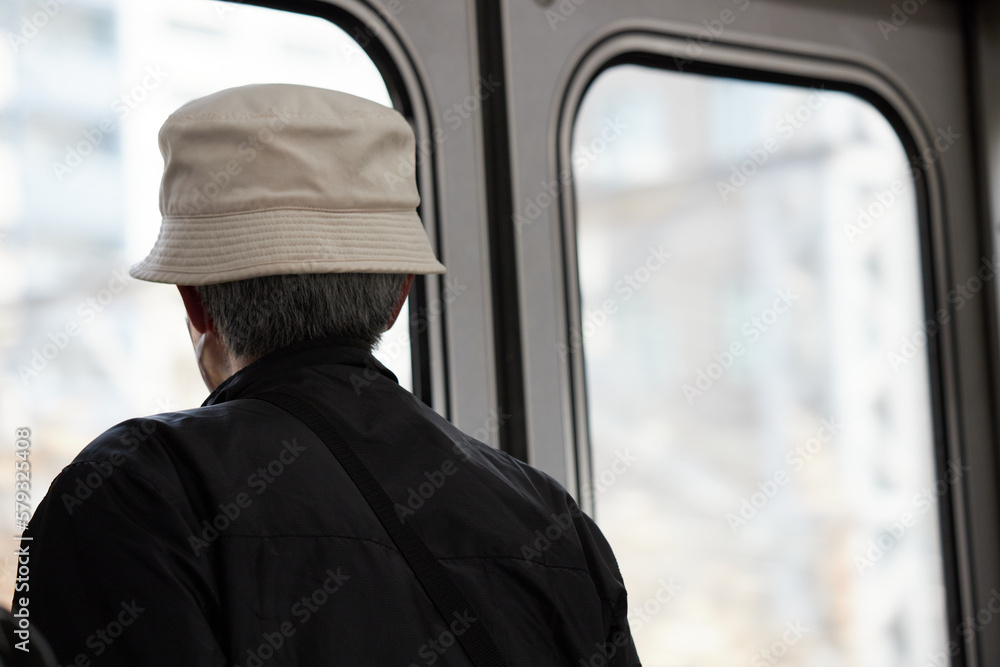 電車を乗っているシニア男性の後ろ姿 電車を乗っているシニア男性の後ろ姿