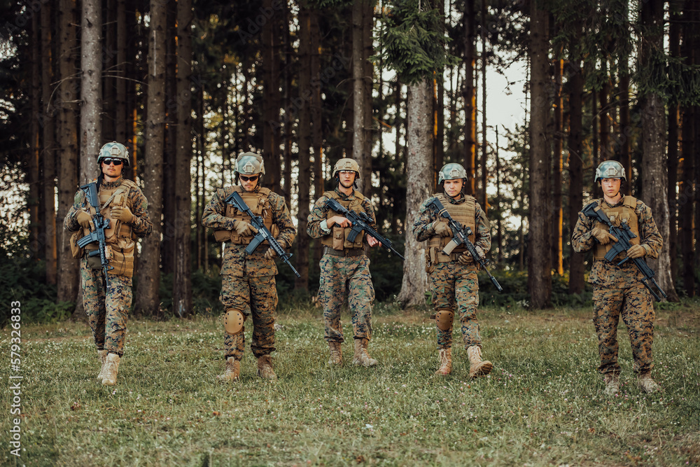 Soldier fighters standing together with guns. Group portrait of US army elite members, private military company servicemen, anti terrorist squad Soldier fighters standing together with guns. Group portrait of US army elite members, private military company servicemen, anti terrorist squad