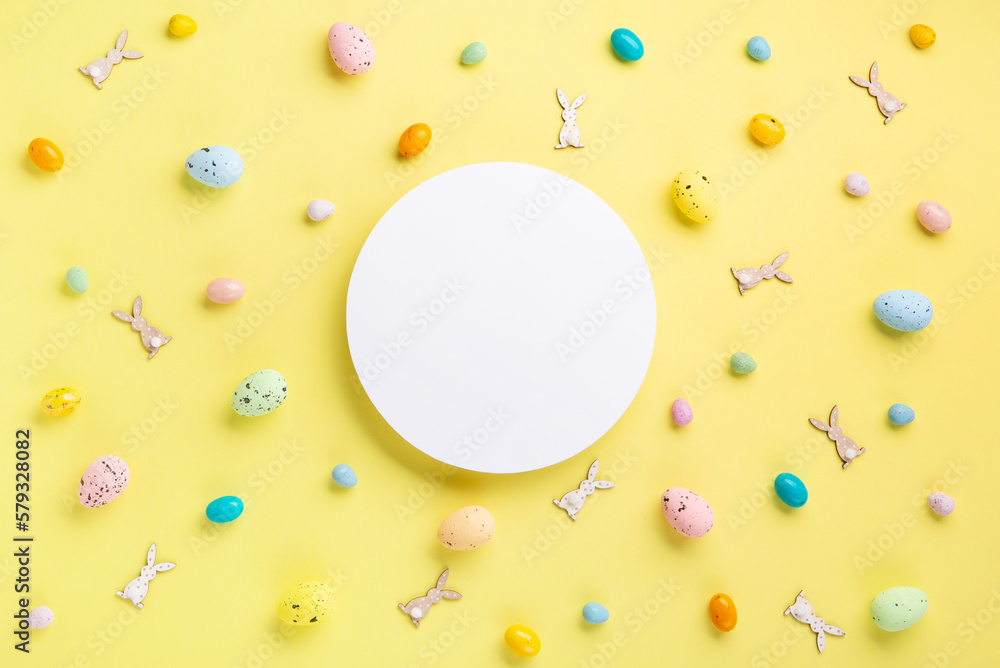 Easter Eggs with Sweets and Spring Flowers on Yellow Background Easter Eggs with Sweets and Spring Flowers on Yellow Background
