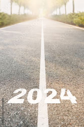 Happy new year 2024. 2024 written on asphalt road. Start the New Year at sunrise. Challenge, planning, and opportunity concept. Vertical Photo