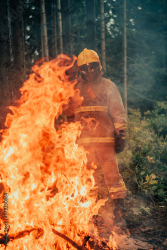 Firefighter at job. Firefighter in dangerous forest areas surrounded by strong fire. Concept of the work of the fire service