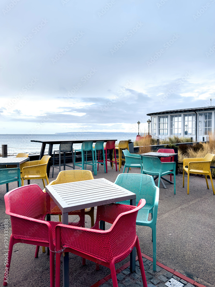 Multi-colored chairs on the terrace of a cafe by the sea.