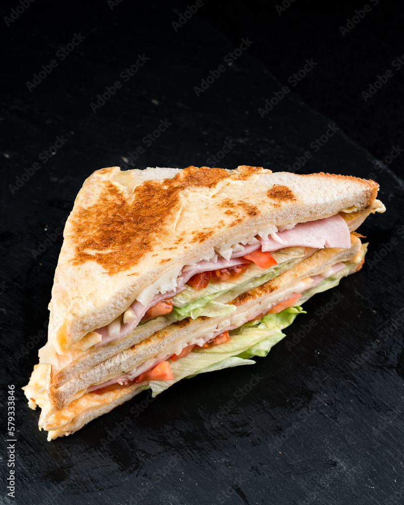 Breakfast toasted bread with chicken ham, lettuce, cheese and tomatoes. Breakfast toasted bread with chicken ham, lettuce, cheese and tomatoes.