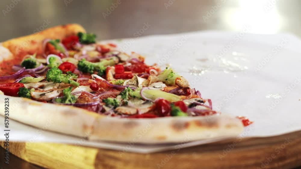 People take the pieces freshly baked appetizing pizza with cherry tomatoes, mushrooms, broccoli, red onion on a tomato base. People take the pieces freshly baked appetizing pizza with cherry tomatoes, mushrooms, broccoli, red onion on a tomato base.