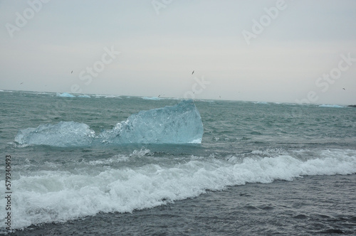 Crystal clear ice chunks floating on the waves of Diamond beach in Fellsfjara,Jokulsarlon on Iceland