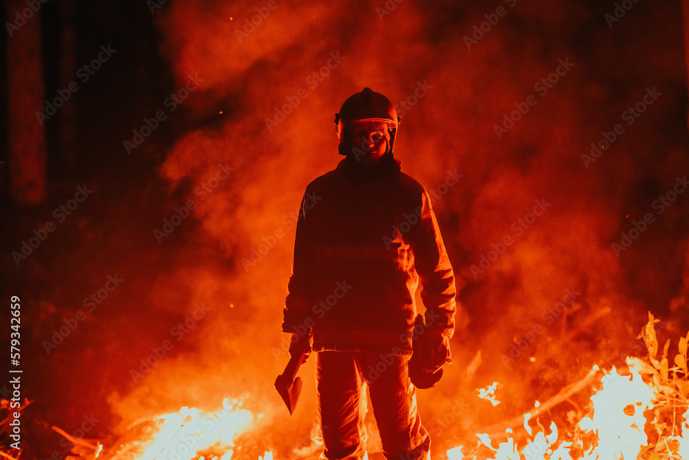 Firefighter at job. Firefighter in dangerous forest areas surrounded by strong fire. Concept of the work of the fire service Firefighter at job. Firefighter in dangerous forest areas surrounded by strong fire. Concept of the work of the fire service
