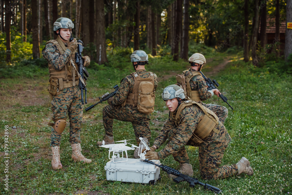 Fototapeta premium Modern Warfare Soldiers Squad are Using Drone for Scouting and Surveillance During Military Operation in the Forest.