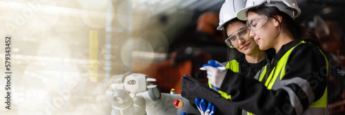 web banner A team of female engineers meeting to inspect computer-controlled steel welding robots. Plan for rehearsals and installation for use.