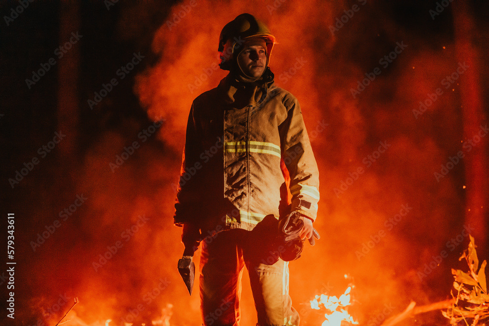 Firefighter at job. Firefighter in dangerous forest areas surrounded by strong fire. Concept of the work of the fire service Firefighter at job. Firefighter in dangerous forest areas surrounded by strong fire. Concept of the work of the fire service