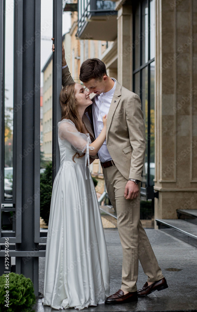 The bride looks at the groom with loving eyes. Smiling newlyweds look into each other's eyes.