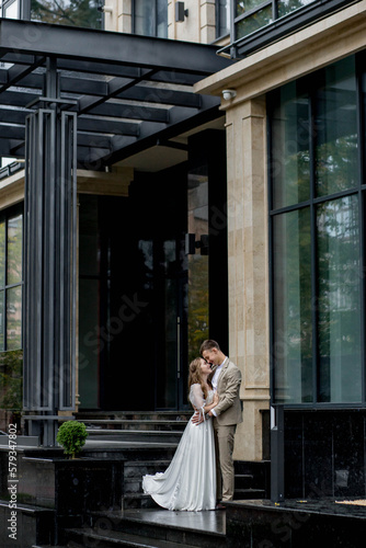 The groom gives his hand to the bride walking down the stairs. Shooting on the wedding day