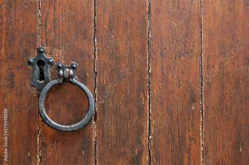 Old antique wooden door. Door with metal handle and large keyhole.