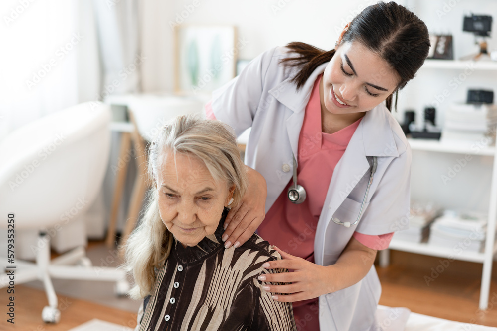 Fototapeta premium Doctor woman take care smiling older caucasian woman of shoulder massage home