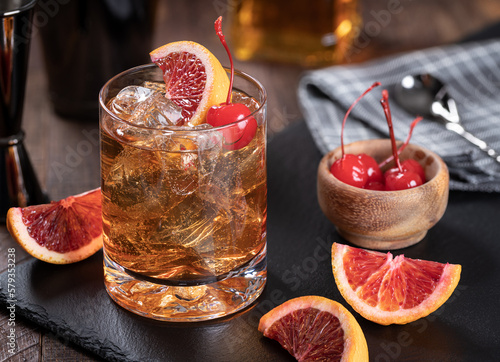 Old fashioned cocktail with cherrry and orange photo