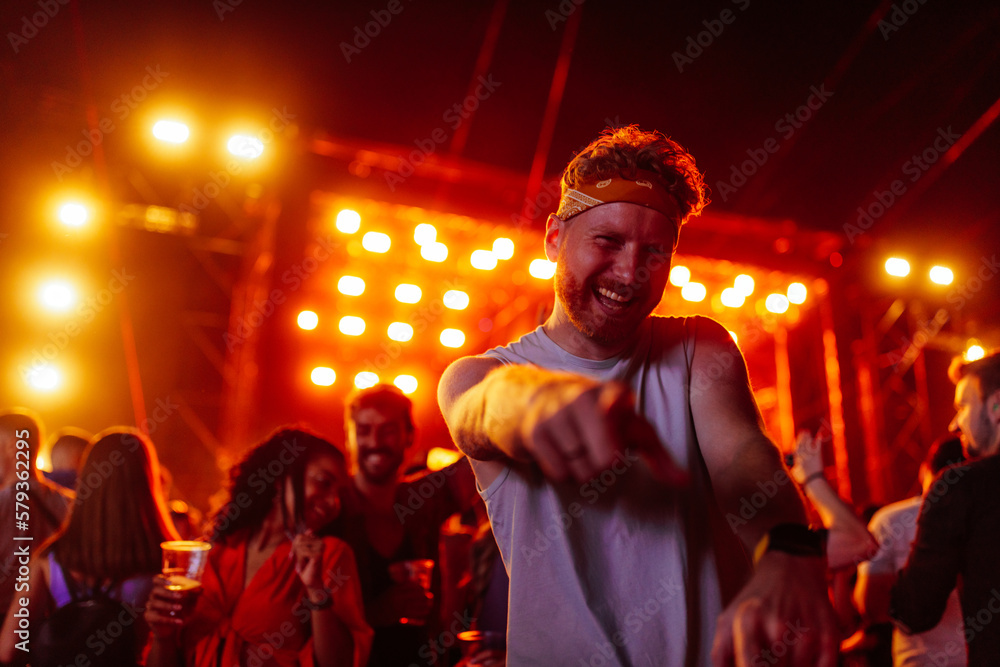Fototapeta premium Excited young adult dancing at music festival