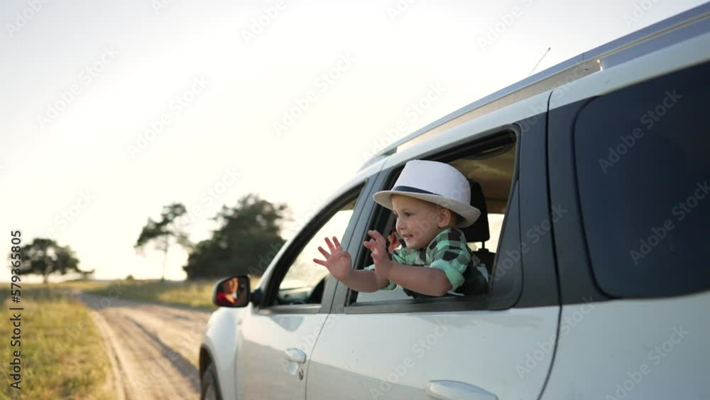 Happy family.Family travel on rural road. Summer vacation in nature. Road trip for children and parents. Toddlers wave from car window Children look out window at sky. Happy family concept. Happy family.Family travel on rural road. Summer vacation in nature. Road trip for children and parents. Toddlers wave from car window Children look out window at sky. Happy family concept.