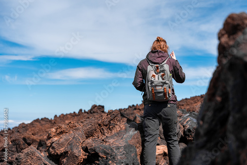 mujer senderista caminando por montaña rocosa, vistas desde el teide
