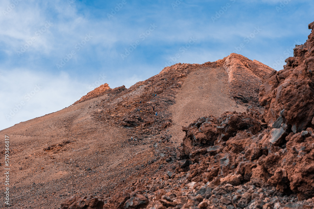 pico del volcán el teide, montaña rocosa siendo subida por senderistas 