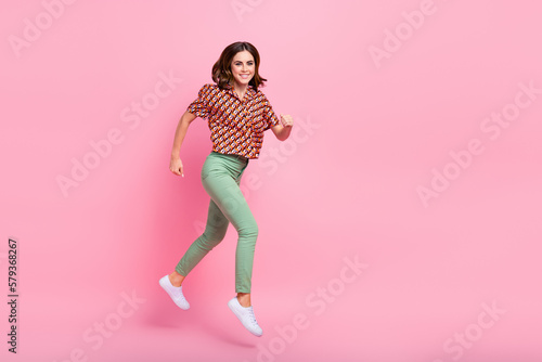 Full length profile portrait of sportive cheerful person jumping rush empty space isolated on pink color background