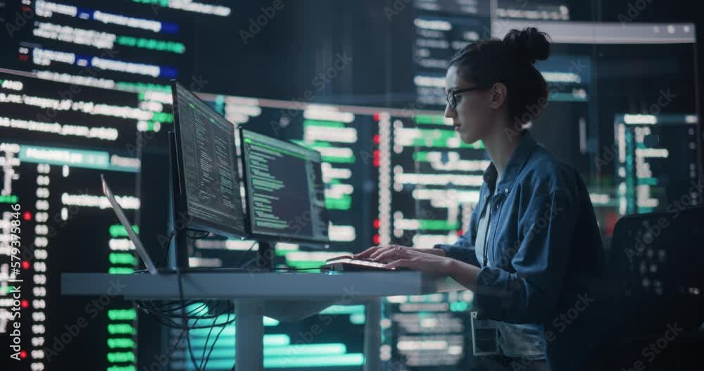 Portrait of Woman Working on Computer, Typing Lines of Code that Appear on Big Screens Surrounding her in a Monitoring Room. Female Programmer Creating Innovative Software Using AI Data and System Portrait of Woman Working on Computer, Typing Lines of Code that Appear on Big Screens Surrounding her in a Monitoring Room. Female Programmer Creating Innovative Software Using AI Data and System