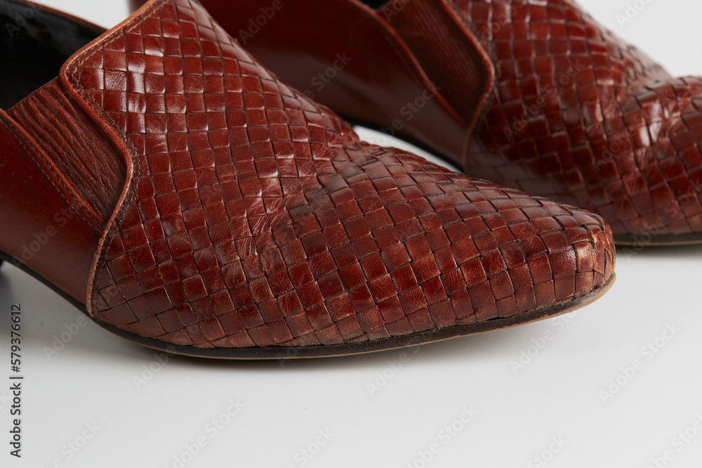 Pair of retro red slip-on shoes. Stylish woven-leather material. Close-up of toe. Pair of retro red slip-on shoes. Stylish woven-leather material. Close-up of toe.