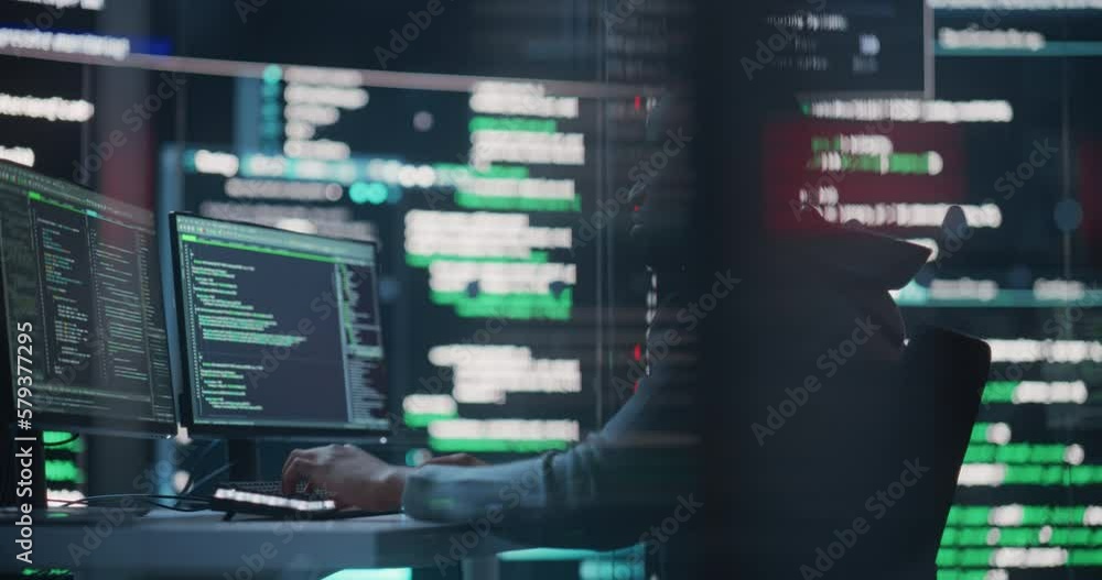 Dolly Shot of a Black Male Programmer Working in a Monitoring Control Room, Surrounded by Big Screens Displaying Lines of Programming Language Code. Portrait of a Man Creating a Software and Coding Dolly Shot of a Black Male Programmer Working in a Monitoring Control Room, Surrounded by Big Screens Displaying Lines of Programming Language Code. Portrait of a Man Creating a Software and Coding