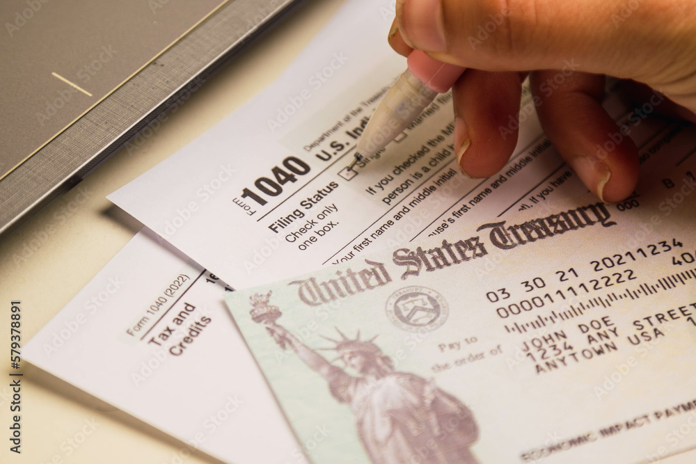 Obraz premium woman hand filling 1040 tax forms , United States tax form, a laptop on a desk. US individual income tax return. Accountant working with US tax forms