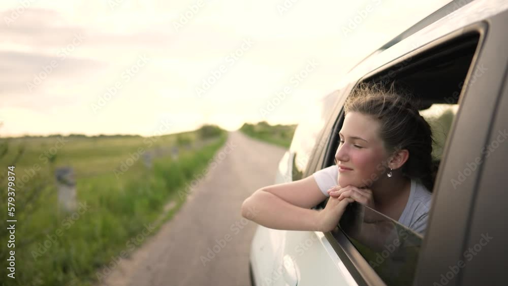 Child in car window. Family car trip. Child hair in wind. Girl looks out of car window. Happy child travel with his family. Girl stretches out his hand to wind. Happy family travel concept by car Child in car window. Family car trip. Child hair in wind. Girl looks out of car window. Happy child travel with his family. Girl stretches out his hand to wind. Happy family travel concept by car
