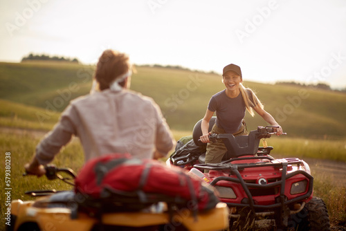 A young couple in love is excited while riding quads in the nature. Riding, nature, relationship, activity
